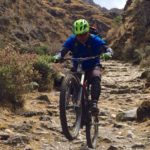 Mountain biker doing a wheelie on a peru bike tour in cusco peru