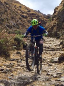 Mountain biker doing a wheelie on a peru bike tour in cusco peru